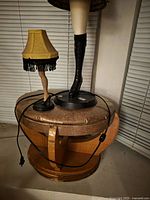 large and small leg lamps on round stool