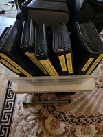 Five black DVD/CD binders standing in clear plastic tub