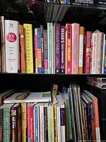 Three bookshelves showing rows of vegan and vegetarian cookbooks and decor pieces