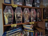 Row of five Living Dead Dolls boxes on shelf