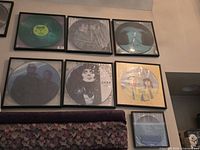 Seven framed picture-disc records displayed on wall