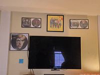 Full view of wall-mounted Sony TV with four framed art pieces above and beside