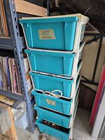 Full view of six turquoise drawers in white frame with some visible contents