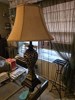 Full view of lamp showing ornate base, shade, cord