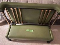 Rear view of olive green kneeling bench showing brass-tone slat accents and padded surfaces