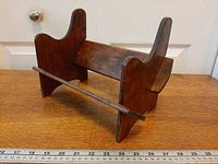 Front view assembled mahogany book trough stand with ruler for scale