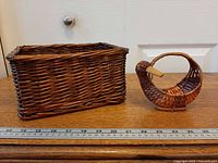Rectangular wicker basket and duck basket side by side with ruler for scale