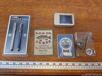 Group shot of all items in lot laid out on wood surface beside ruler