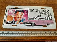 Front view showing entire license plate with ruler for scale