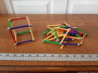 Cube model demonstrating rods and connector spheres with pile of remaining pieces