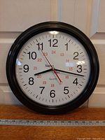 Front view of wall clock showing 12-hour and 24-hour markings