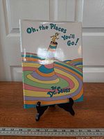 Front view of hardcover book standing on easel showing full dust jacket artwork