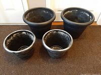 Four polyresin planters, two sizes shown together