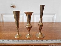 All three brass vases side by side with ruler for scale