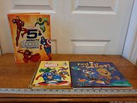Three Marvel children’s books on table with ruler for scale