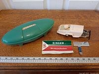 Jetson case, buttonholer attachment, leaflet, feed plate, blue tool laid out on table