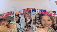 Several FEMINA magazine covers spread out showing variety of issues