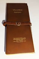 Front of brown leatherette booklet with strap, gold text