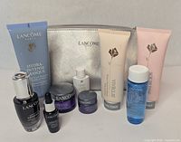 All Lancôme skincare items and silver pouch arranged together