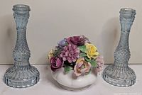 Front view showing porcelain floral bowl flanked by two blue pressed glass candlesticks