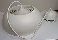 Top view of white plastic dome pendant light with cord and separate canopy