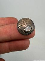 Front view showing domed silver disc, diagonal lines, and bezel-set opal cabochon