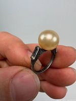 Side view of sterling silver ring showing pearl and rectangular stone