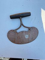 Full view of curved cast-steel chopper with wooden T-handle