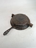 Closed waffle iron showing exterior and handle