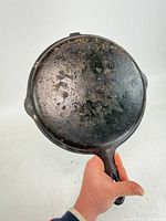 Top side of cast iron lid showing seasoned surface and handle