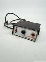 Front view showing dial, switch, red lens, branding