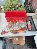 Overall view of toolbox and assorted plumbing tools on table