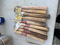 Stack of nine hickory hammer handles of various brands