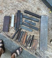 group of mixed oilstone sharpening stones laid out on plywood surface