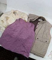 Overall view of vest, blouse, and tank top laid out