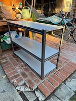 Front view of steel storage shelf with three shelves