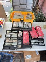 Overview of yellow and black organizers filled with collated nails, staples, and red Senco boxes