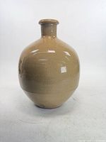 Front view of beige stoneware vase showing overall form and glaze