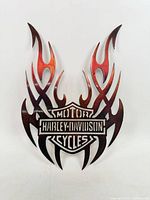 Full view of the steel flame sign showing logo and flame pattern