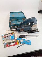 Overall lot with jigsaw, case, blades, screwdriver, rod