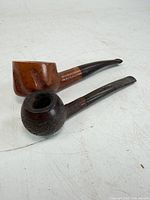 Two wooden smoking pipes, one smooth light burl, one dark rusticated