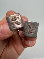 Front view showing carved pinecone design on both square earrings