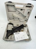Finish nailer in open molded case with manual and accessories visible