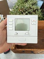 Front view of PRO digital thermostat showing buttons, screen, and logo