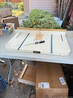 Full view of router table top on workbench with fence and clamp