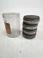 Stack of four Rockler Bench Cookie Plus pads beside clear storage tube