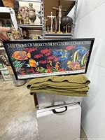 Full view of framed Monterey Bay Aquarium poster resting on blanket