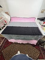 Full view of crocheted blanket laid flat showing three color bands