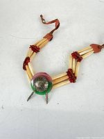 Full view of handmade choker showing hair-pipe beads, red spacers, stone and concho centerpiece, leather ties