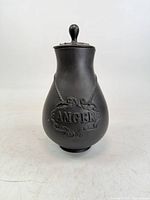 Front view showing ANGER plaque and lid